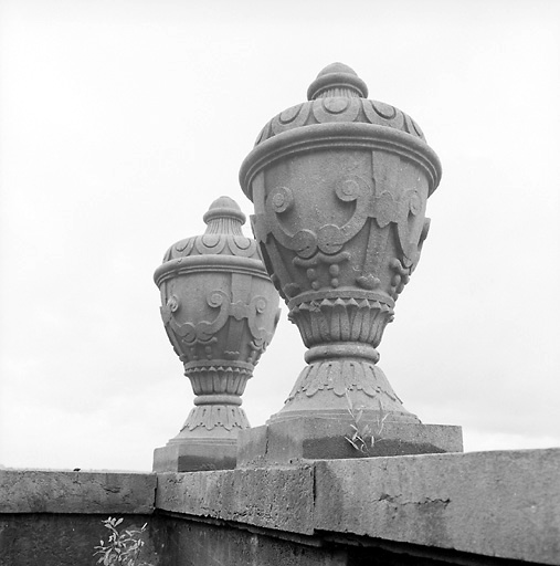 Façade : vases Médicis en pierre sommant la balustrade devant le comble.