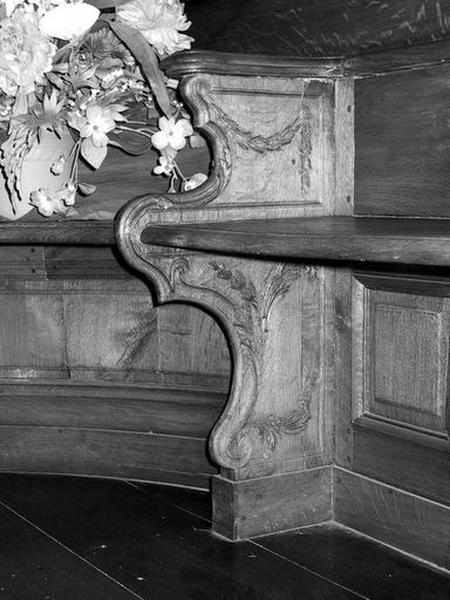 Détail : banc fixe, jouée et parclose avec décor sculpté.