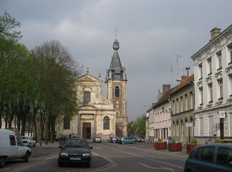 Côté nord-est de la place : façade de l'église paroissiale Saint-Wasnon ; à droite, le côté sud-est.