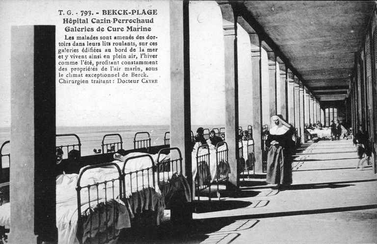 Elévation antérieure, galerie du cure du rez-de-chaussée prolongée par une terrasse où sont alignés les lits de malade, vue en enfilade. Carte postale, vers 1925 (coll. part.).