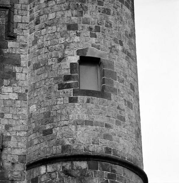 Corps de logis médiéval, façade, tourelle est, 2e étage : baie couverte par un linteau en bâtière reposant sur des coussinets.