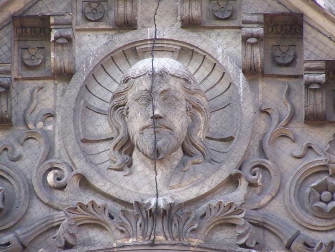 Détail du visage du Christ sur le couronnement du portail.