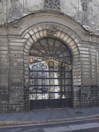 Vue de la porte cochère fermée par une grille de style Art déco.