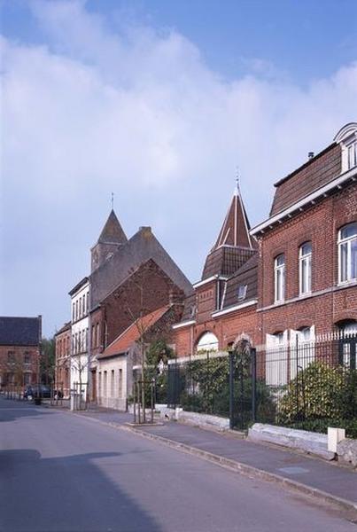 Vue générale de la rue de l'Eglise : ferme (premier plan, n° 51-59), maison à trois niveaux (n° 23).