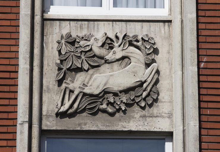 Bas-relief représentant une biche et un cerf au milieu de la végétation.