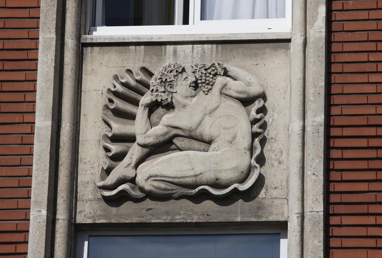 Bas-relief représentant un homme dans un coquillage portant à la bouche une grappe de raisin-Evocation du dieu romain Bacchus.