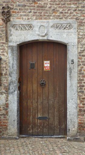 Façade-pignon, détail : porte dont le linteau affiche la date de construction et le monogramme du duc de Croÿ.