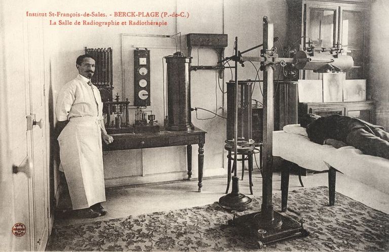 Pavillon dit de la clinique, salle de radiographie, vue générale avec le docteur François Calot et un malade allongé sur la table d'examen. Carte postale, début du 20e siècle (coll. part.).