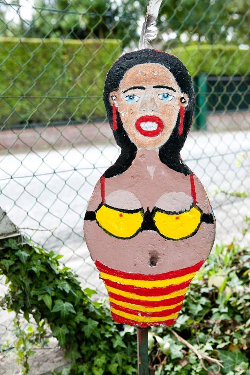 Figure féminine en ciment installée devant la maison.