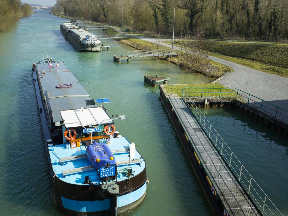 Estacade de guidage et appontements à l'aval. La péniche Freycinet "Marie-Lou" sortant de l'écluse et se dirigeant vers la jonction Sensée-canal de Dunkerque-Valenciennes. En arrière-plan, le convoi poussé "Kenza".