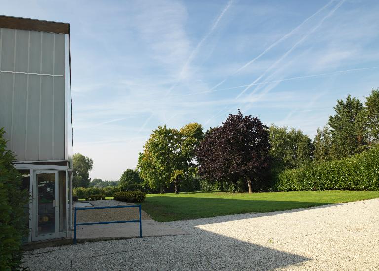 Entrée secondaire (aménagée à l'extrémité du "foyer") et jardin de la piscine. 