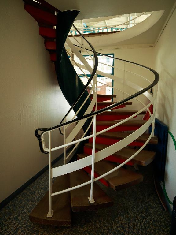 Escalier hélicoïcal menant à la tribune située au-dessus du hall d'entrée et surplombant les bassins.