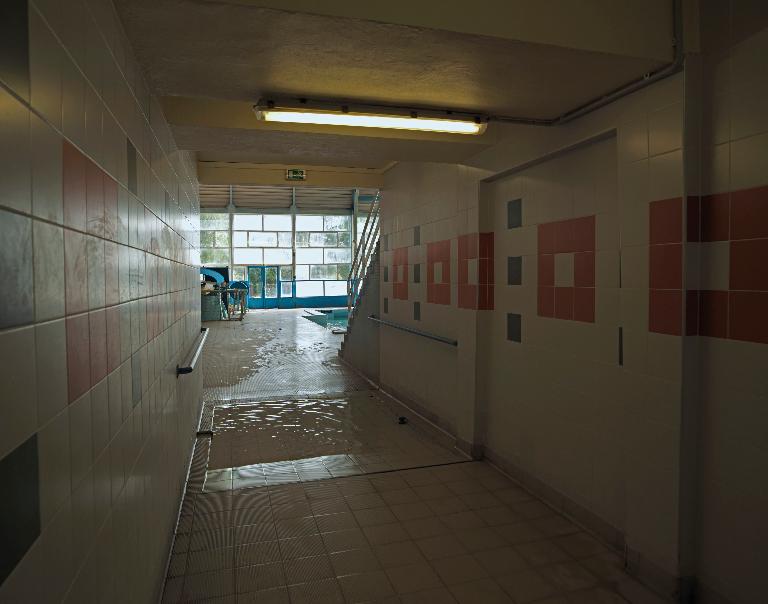 Couloir menant des douches vers la halle des bassins (arrivée vers le petit bassin) en passant par le pédiluve.