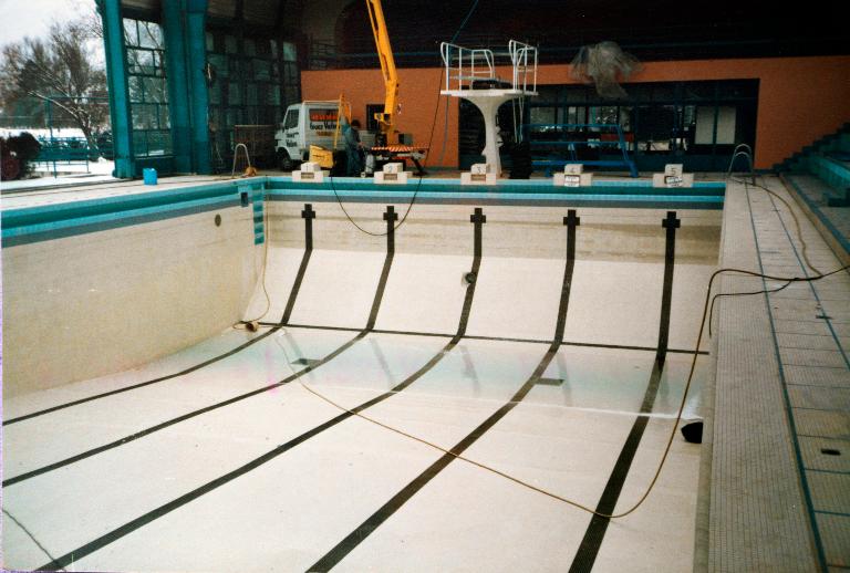 Vue du bassin sportif vide (3,5 mètres de profondeur) lors de travaux, vers 1990 (archives de la piscine). 
