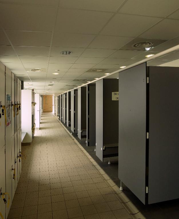 Vue générale des vestiaires (casiers et cabines individuelles).