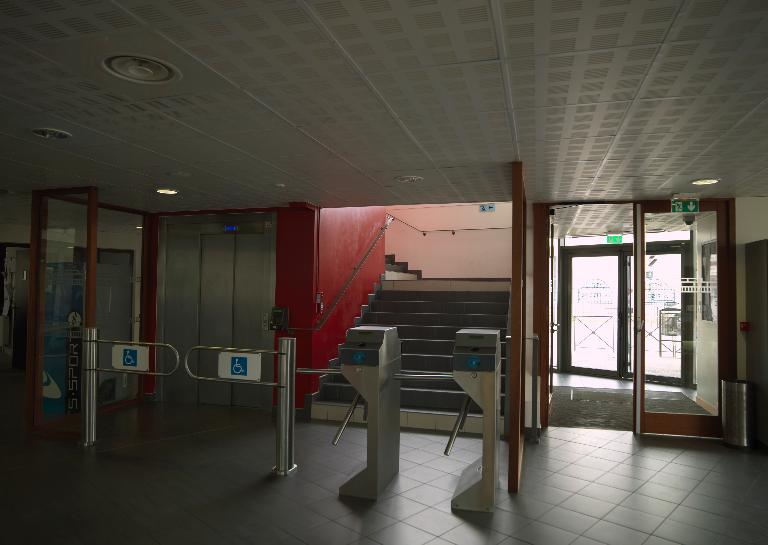 Hall d'entrée de la piscine : tourniquets menants aux vestiaires.