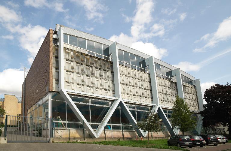 Façade sud, sur la rue de la Commune de Paris; au rez-de-chaussée, baies vitrées donnant sur le bassin.  ; Saint-Omer (Pas-de-Calais). La piscine Solaris (1973), construite sur les plans de l'architecte Maurice Ego.
