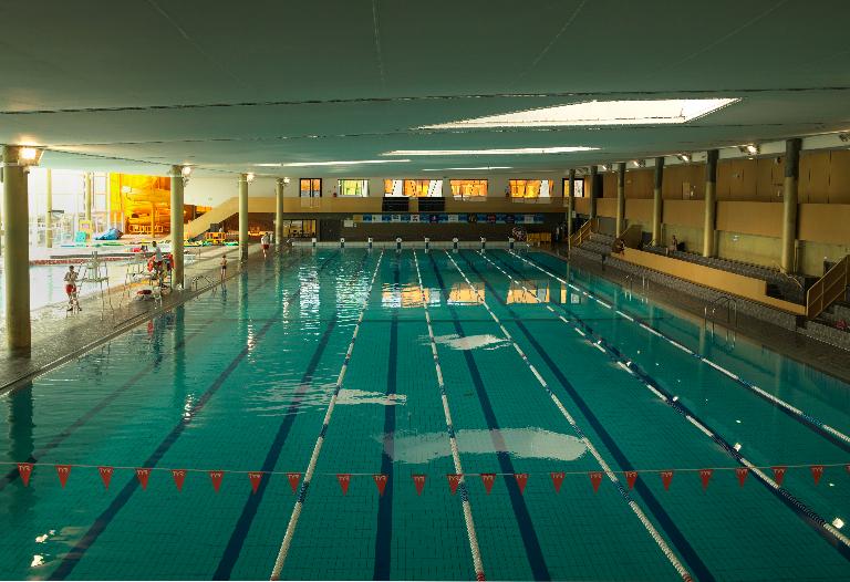 Vue générale du bassin olympique et des tribunes, vers la terrase d'accès au solarium.
