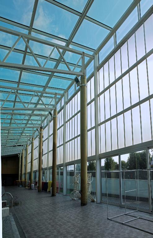 Façade est (côté bassin d'apprentissage), ouverte sur l'extérieure par des parois vitrées translucides (partie haute) et transparentes (partie basse); partie couverte d'une verrière. 