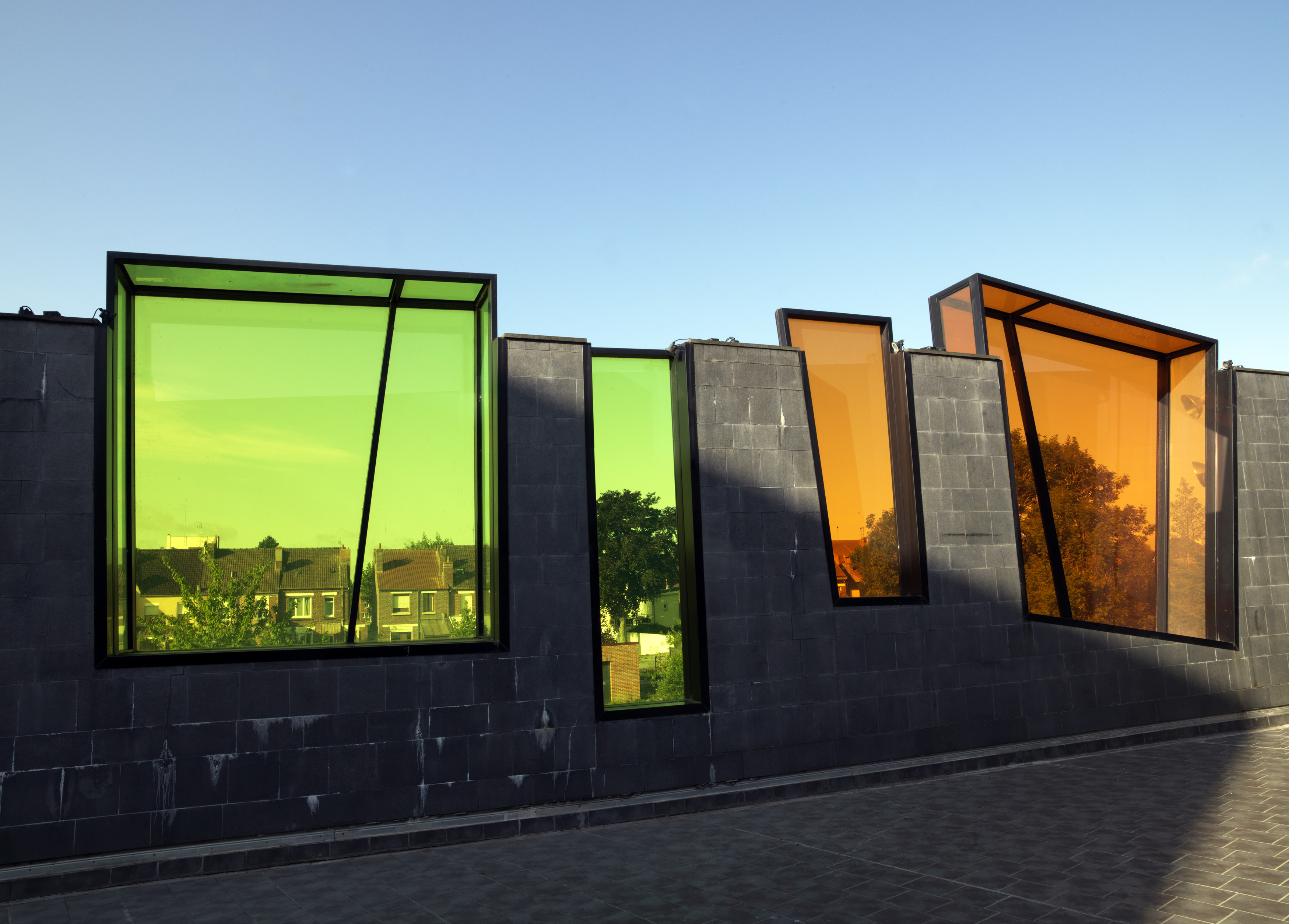 Détail des cubes en verre colorés encastrés dans les murets délimitant la terrasse-solarium, qui donnent vue sur la ville et encadrent les maisons béthunoises.