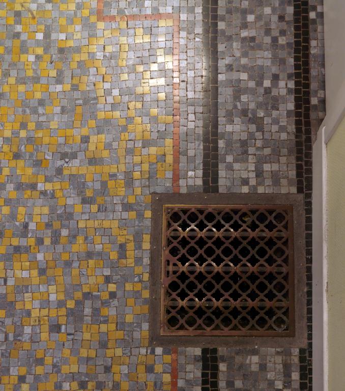 Détail du carrelage et de la bouche de chauffage de l'entrée.