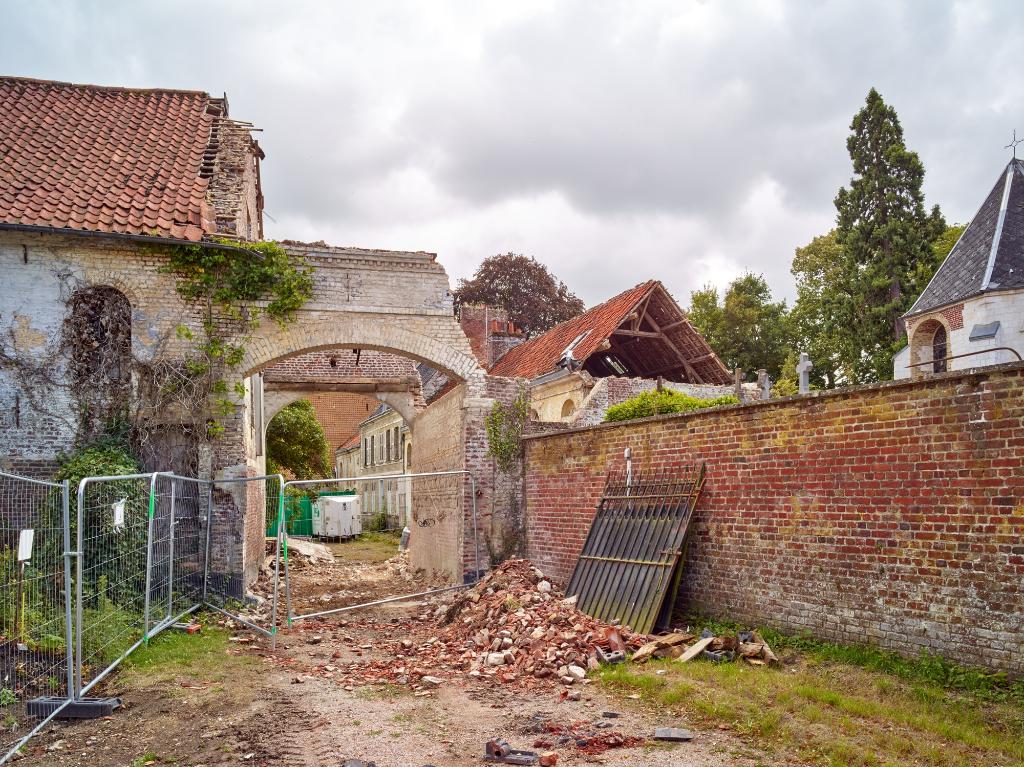 Ferme des Berceaux en 2018 : porche et extrémité de l'écurie vus depuis la rue. Les "rouges barres" sont visibles sur le mur pignon du porche.