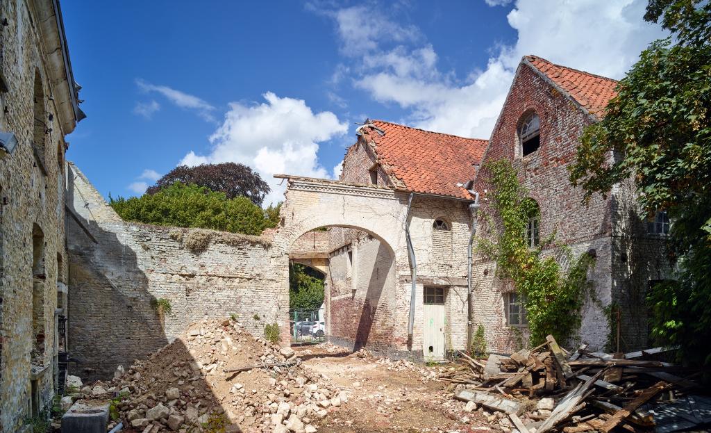 Ferme des Berceaux en 2018 : porche et extrémités de l'écurie et de l'atelier de fabrication de noir animal vus depuis la cour. Traces de l'escalier encagé hors-oeuvre sur le mur à gauche du porche.