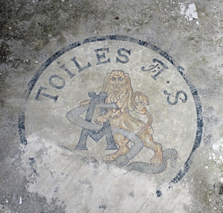 Bureaux, vue intérieure. Blason au sol en mosaïque, aux armes de l'entreprise.