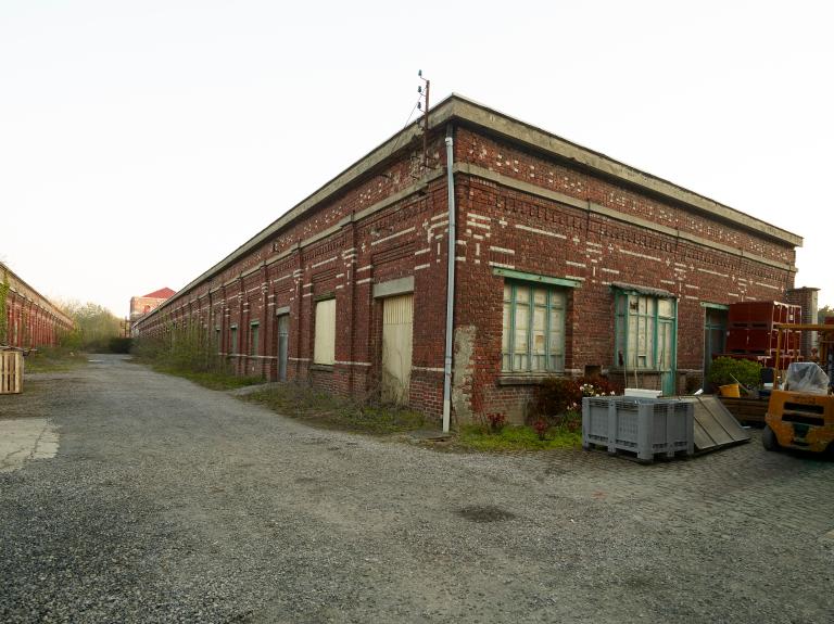 Vue prise vers le nord entre le tissage à gauche et le magasin aux fils à droite.