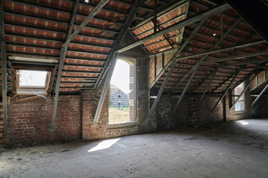 Vue intérieure d'une lucarne des anciennes grandes étables.