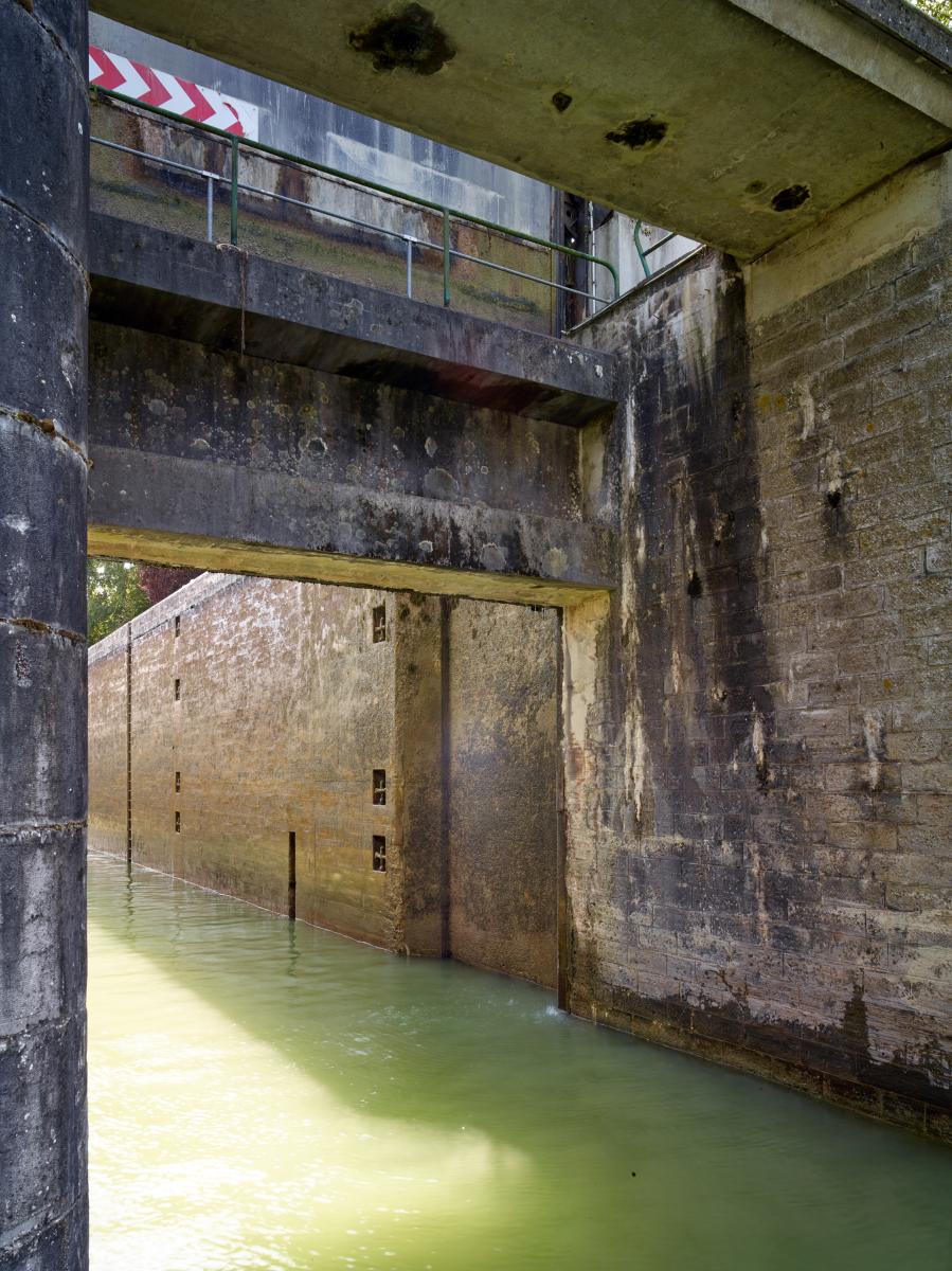 Porte levante en aval et vue du bajoyer maçonné de l'écluse.