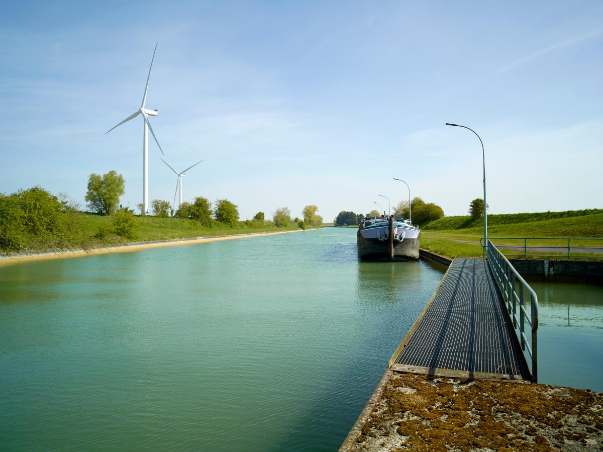 Aval du site d'écluse. Passerelle du bassin de tranquillisation, péniche stationnée.
