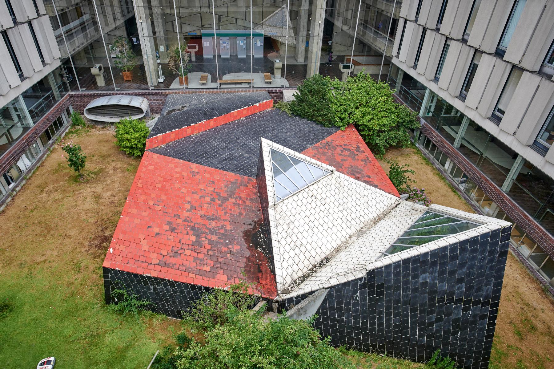 Le patio, animé d'une sculpture monumentale et ouvert par un lanterneau qui éclaire l’ancienne grande salle d’audience du tribunal d’instance au sous-sol.