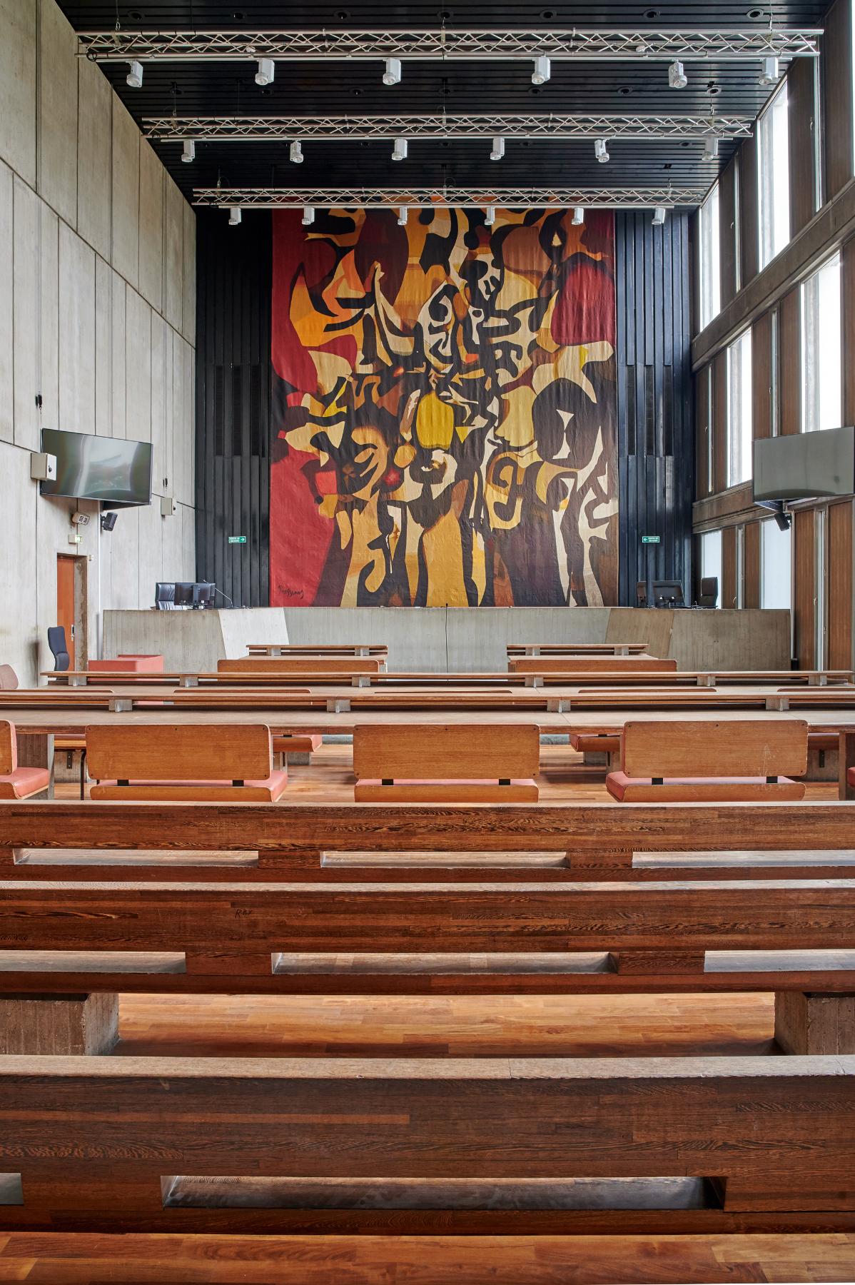 Une salle d’audience du rez-de-chaussée haut accessible par la salle des pas perdus. Le mur du fond est orné d’une tapisserie de Mario Prassinos, « Le Chêne de Saint-Louis »,