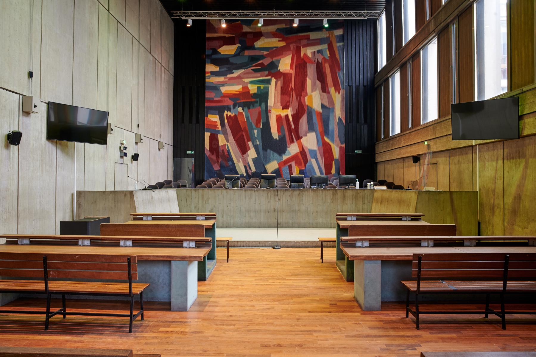 Une salle d’audience du rez-de-chaussée haut accessible par la salle des pas perdus. Le mur du fond est orné d’une tapisserie de Jean Bazaine.