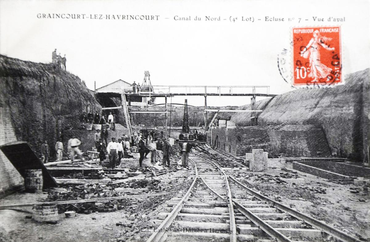 Chantier de l'écluse : réseau ferré technique en fond de fouille et observation de la base des bajoyers en cours de construction, carte postale, entre 1908 et 1914 (collection particulière).)