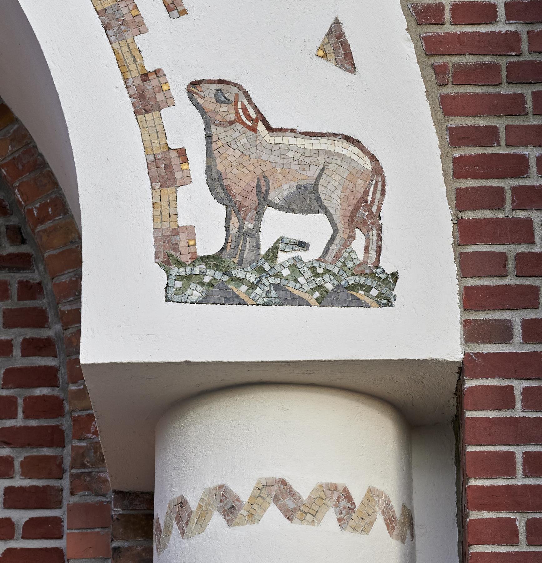 Vue de détail de l'agneau en mosaïque décorant les sommiers de l'arc aveugle du clocher-porche côté ouest.