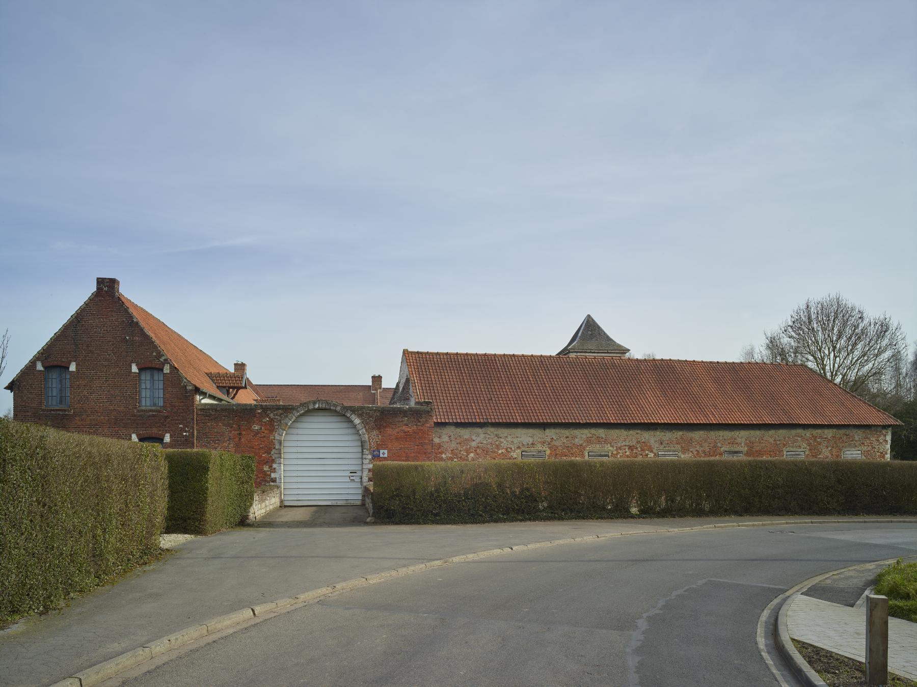 Façade sur rue. Entrée charretière et logis sur la gauche.