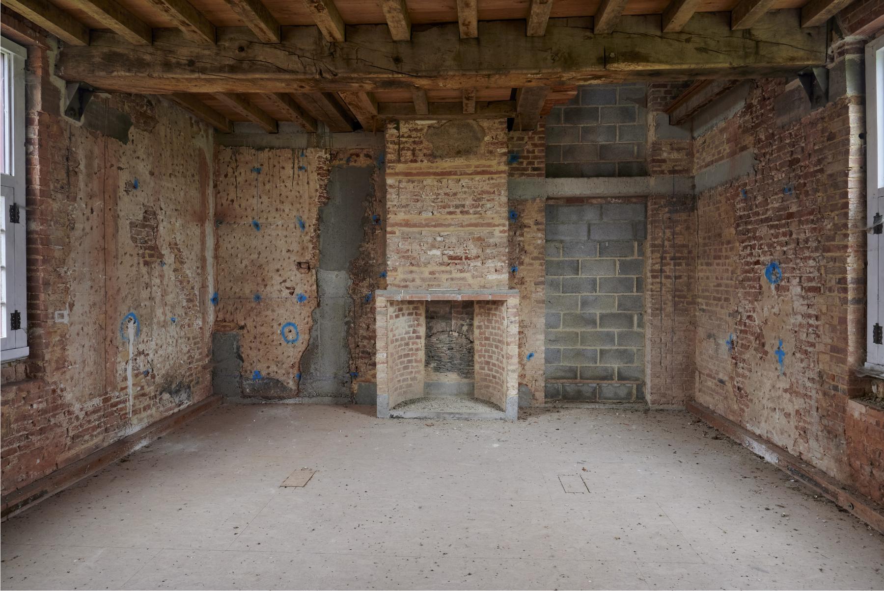 Premier étage. Logis du XVIIe siècle. Dernière salle à l'est du bâtiment. Âtre de cheminée originel. Accès vers les combles.