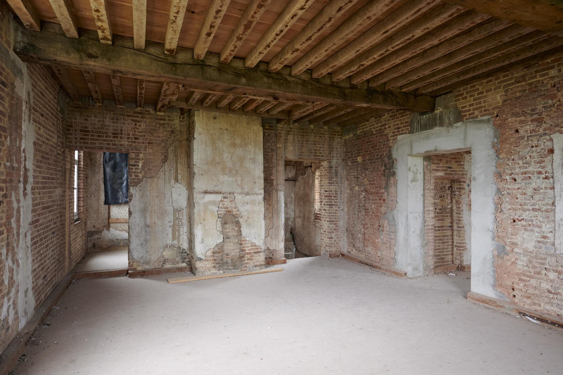 Premier étage. Logis XVIe siècle. Chambre. Vue vers la cheminée, le réduit et la cage d'escalier.