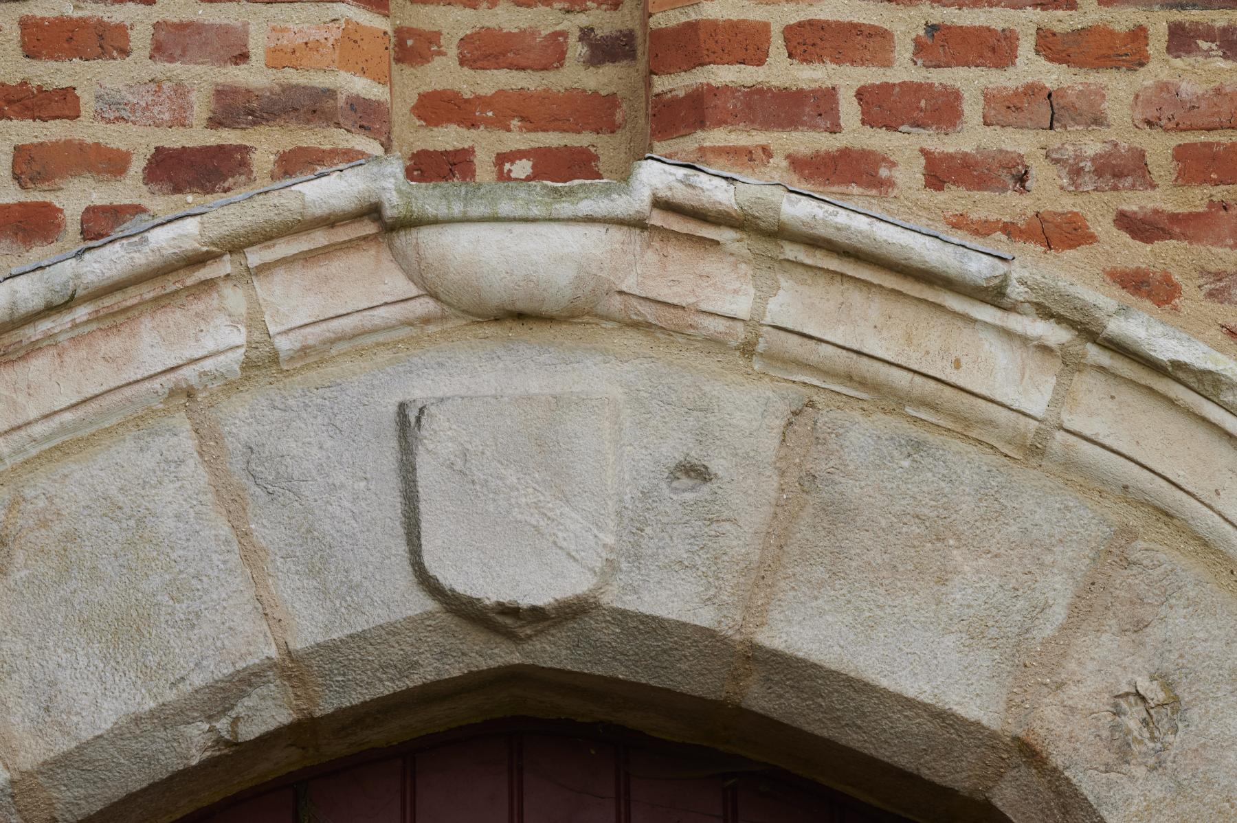 Détail de la porte du logis du XVIe siècle. Blason sur la clé de voûte.