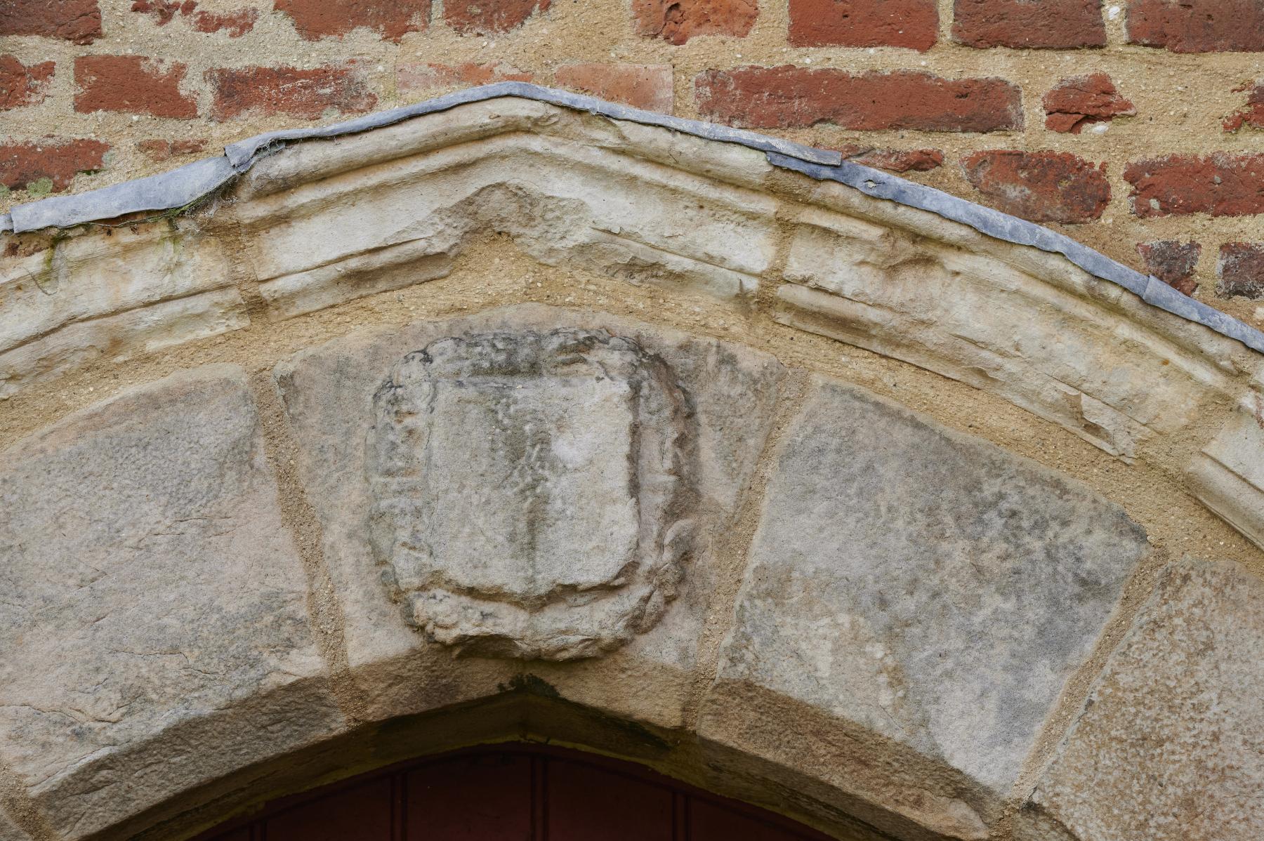 Détail de la porte menant aux cuisines du logis du XVIIe siècle. Blason.