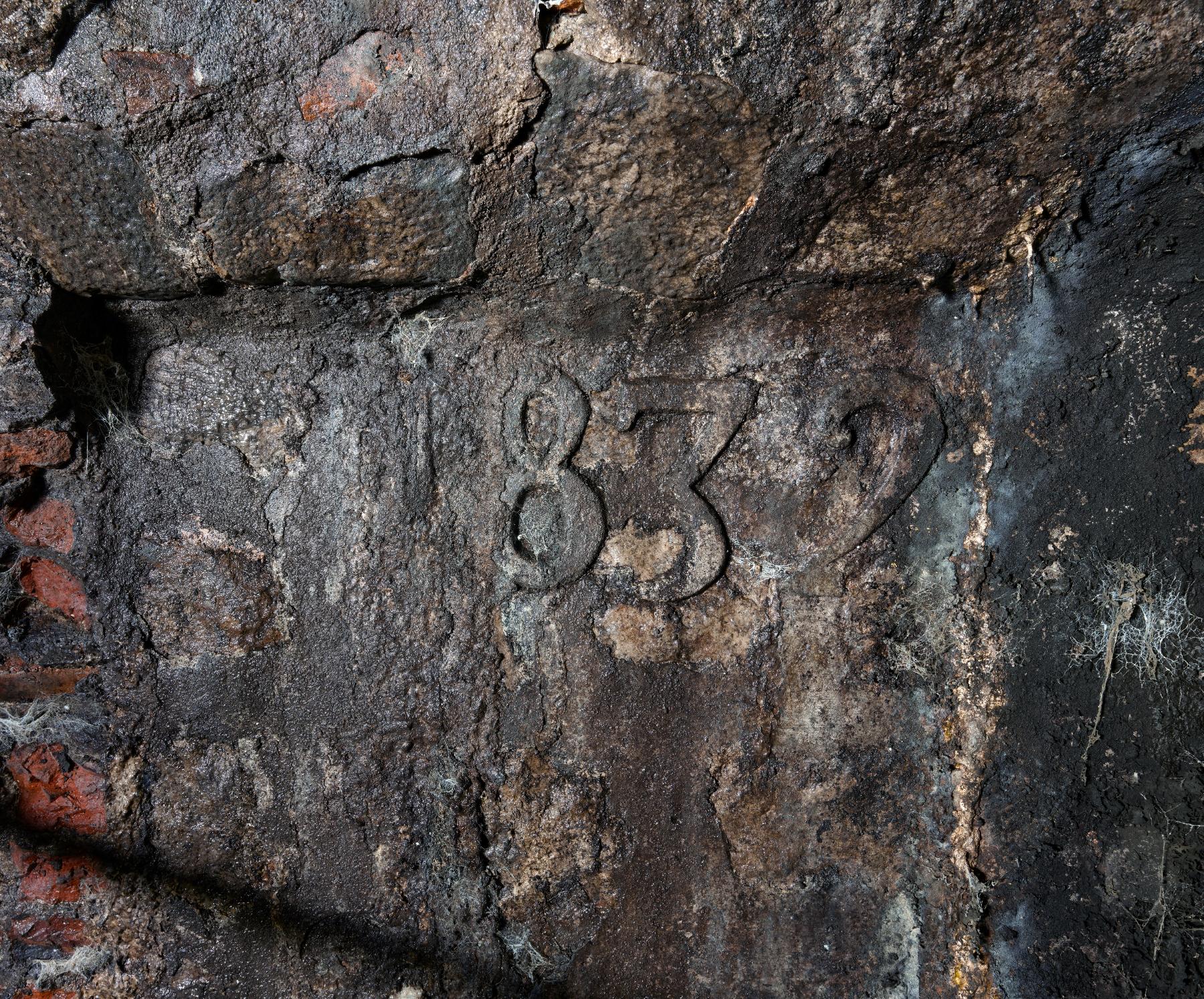 Bâtiment K, détail de la date de 1832 gravée au sous-sol du bâtiment.