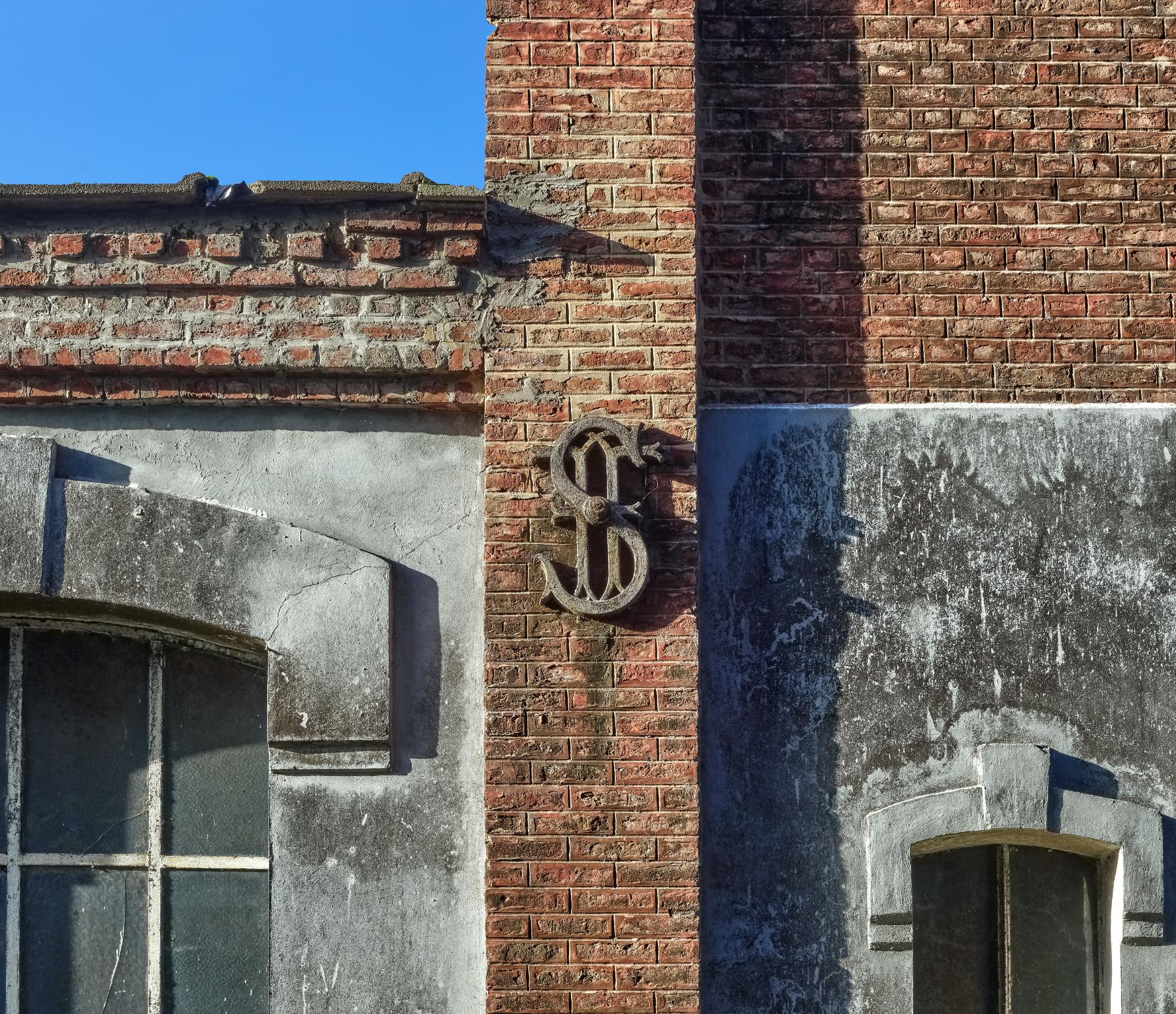 Détail d'un fer d'ancrage portant les initiales entrelacées de l'industriel.