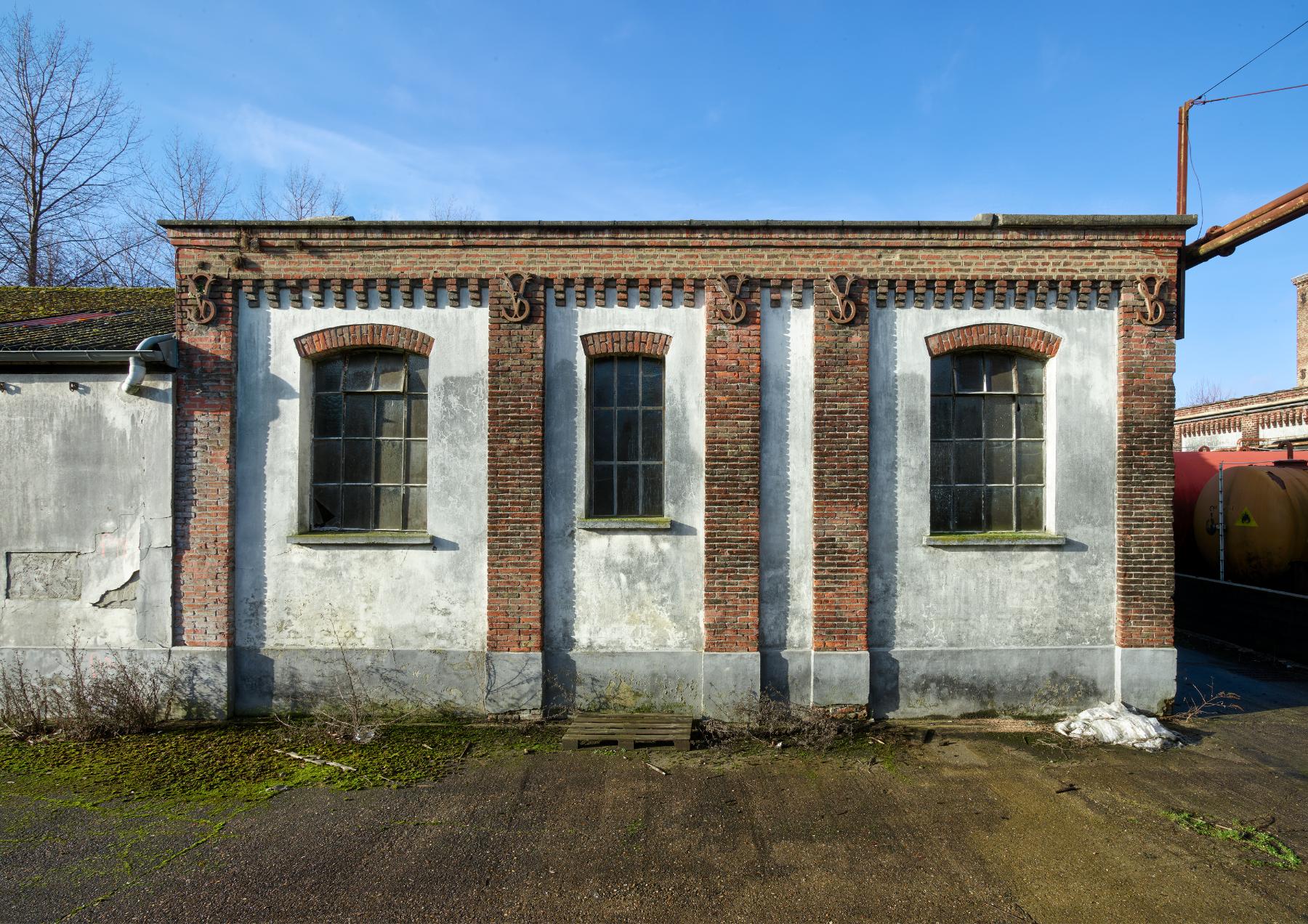 Détail des trois premières travées de la façade est d'un des ateliers portant les initiales VS en fers d'ancrage (bâtiment M).