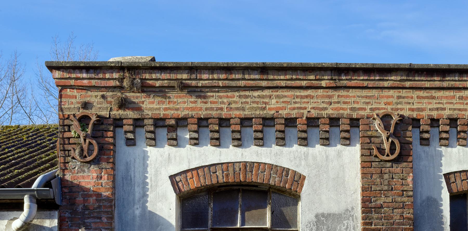 Détail des fers d'ancrage portant les initiales VS sur la façade est d'un des ateliers (bâtiment M). 