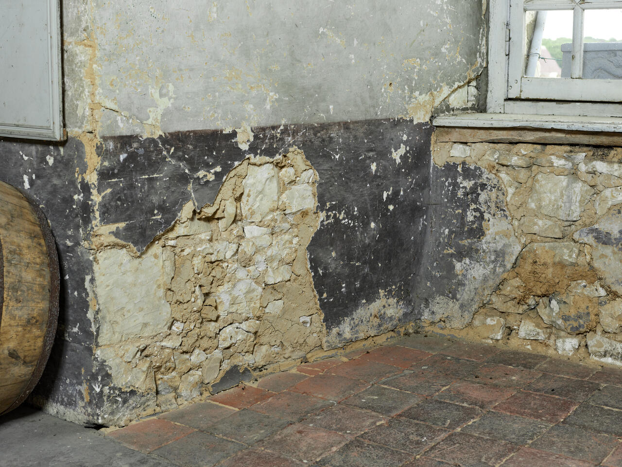 Intérieur de la salle du Conseil d'échevinage, au premier étage du beffroi. Détail du mur intérieur composé de moellons équarris recouvert d'un enduit en torchis.