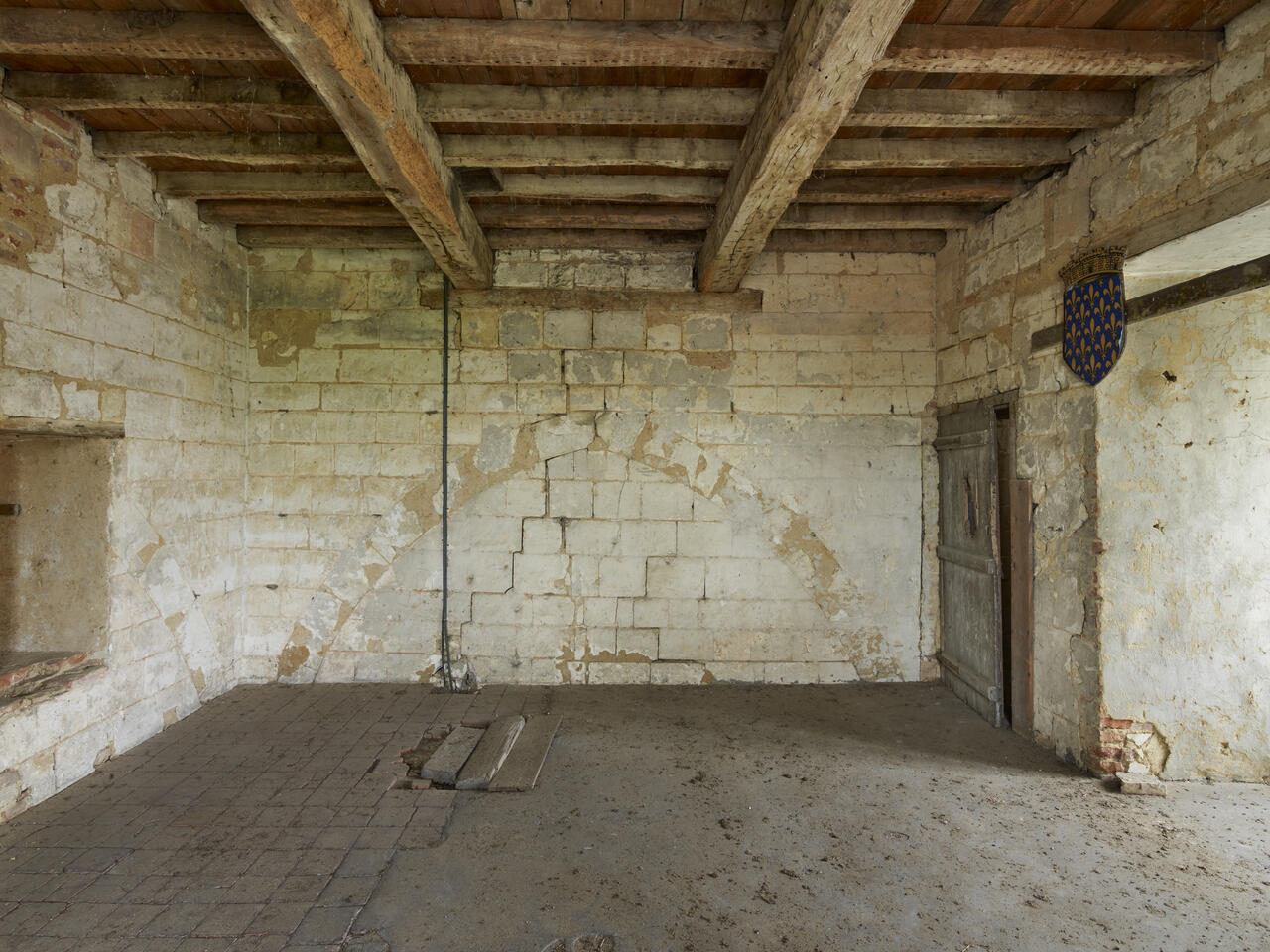 Vue intérieure de l'ancienne salle des gardes dont le mur conserve la trace de l'ancienne voûte d'ogives.
