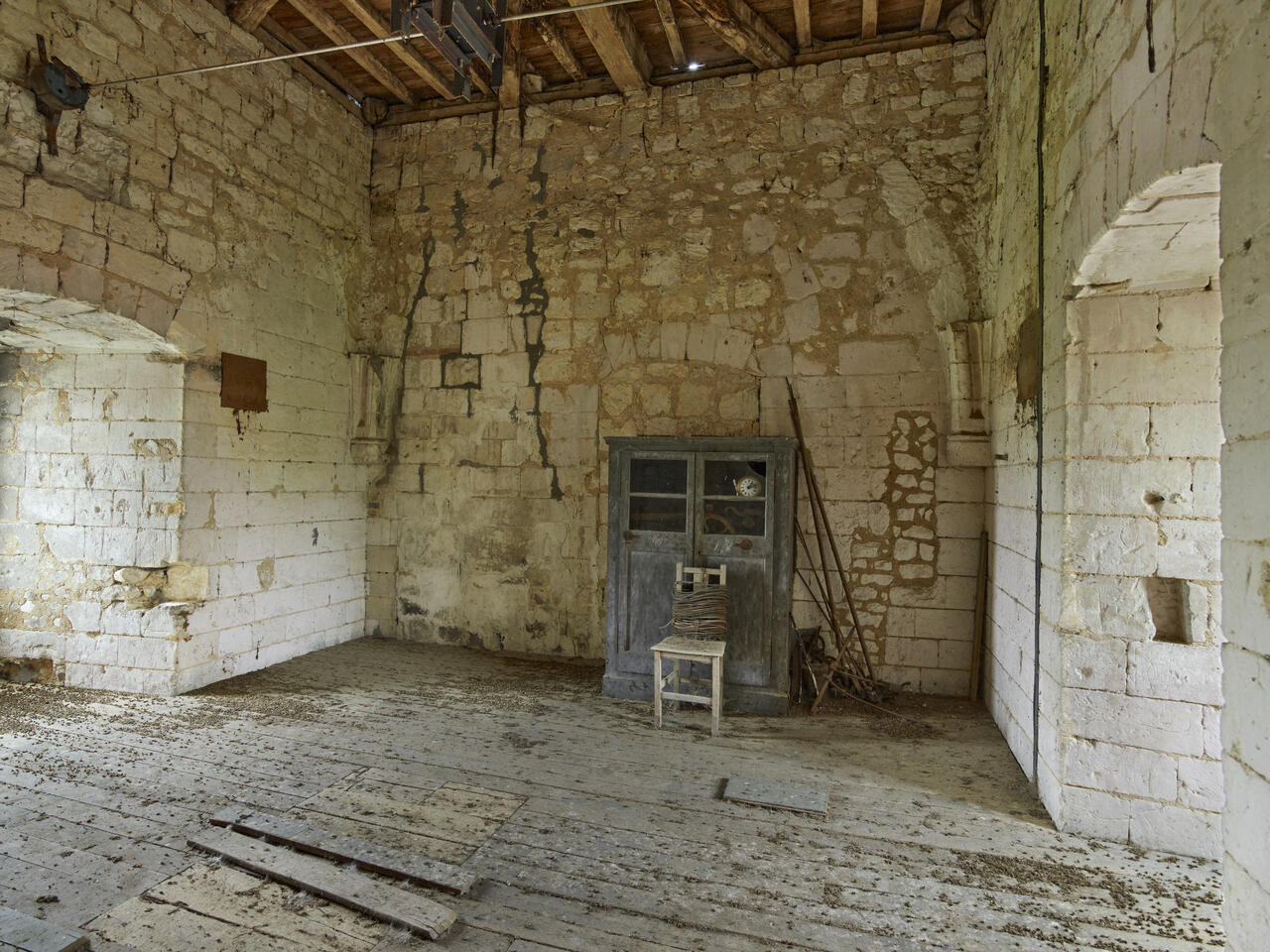 Vue intérieure de l'ancienne salle des remises portant la trace de sa voûte d'ogives primitive.