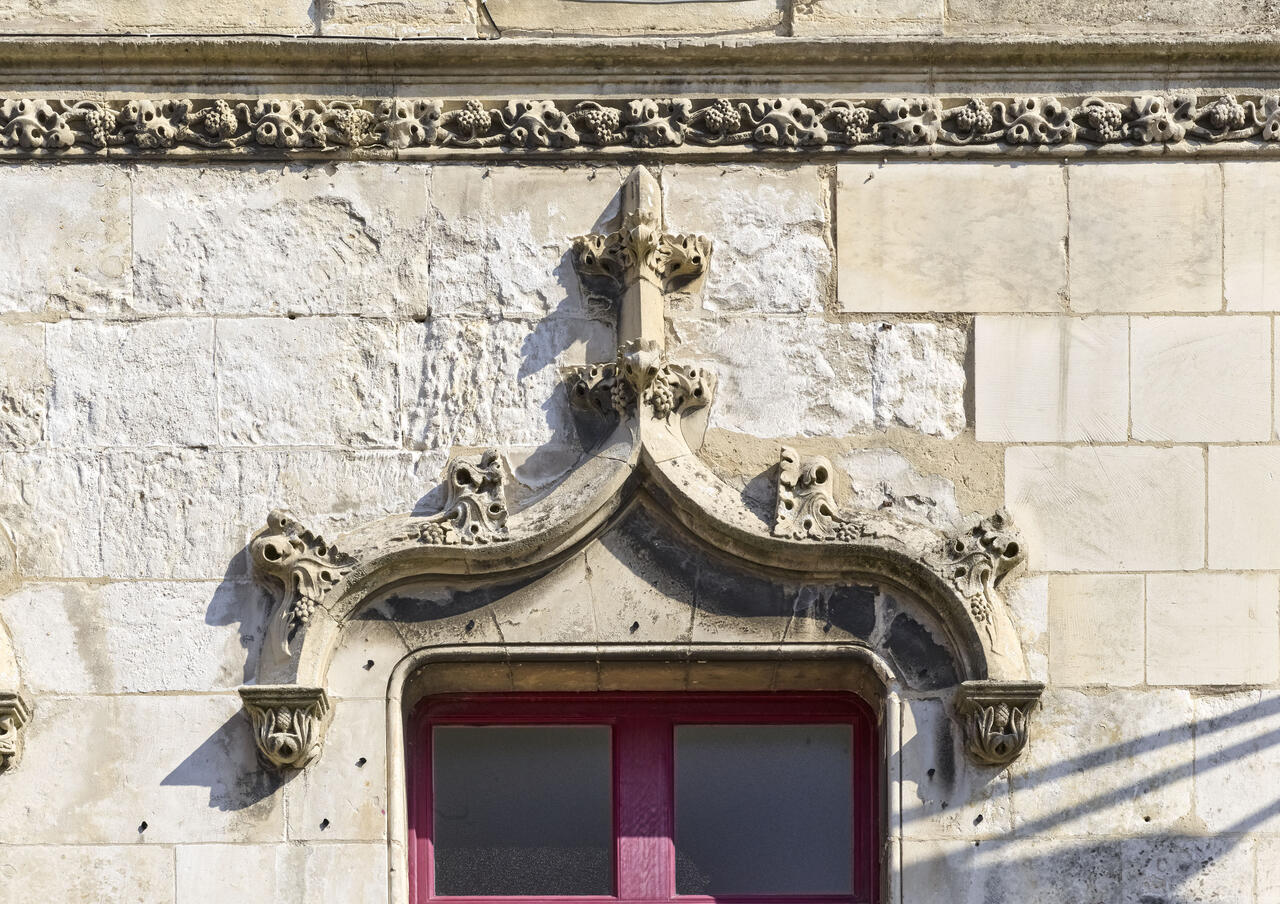 Détail de la frise ornée de ceps de vignes et d'un arc en accolade néo-gothique d'une des baies de la façade ouest.
